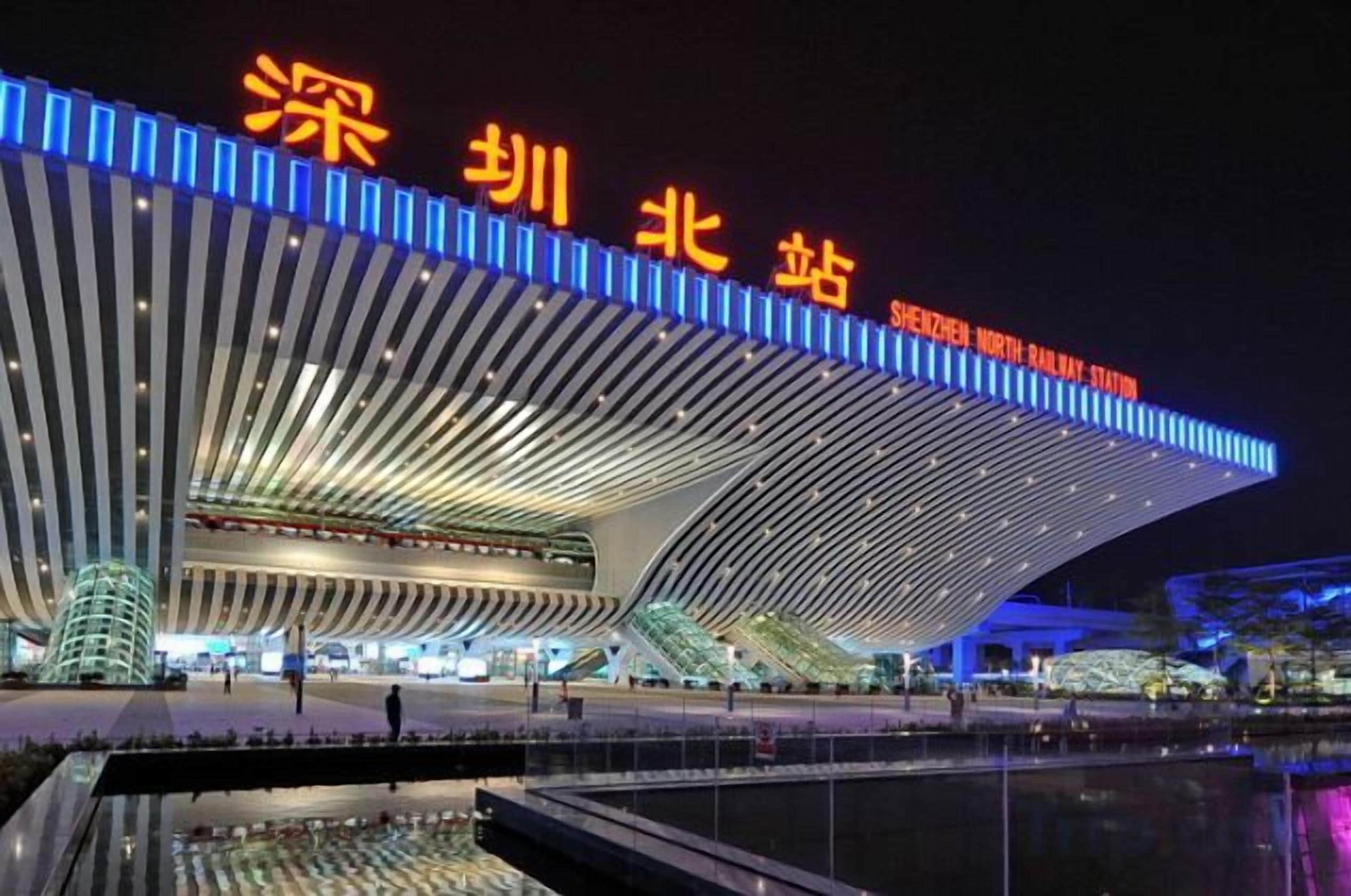 A modern architectural building with a curved roof and illuminated signage.