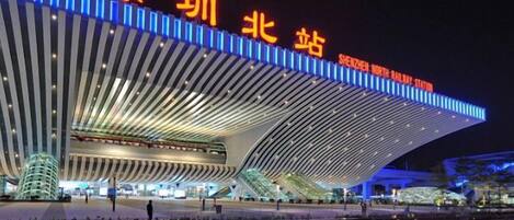 A modern architectural building with a curved roof and illuminated signage.