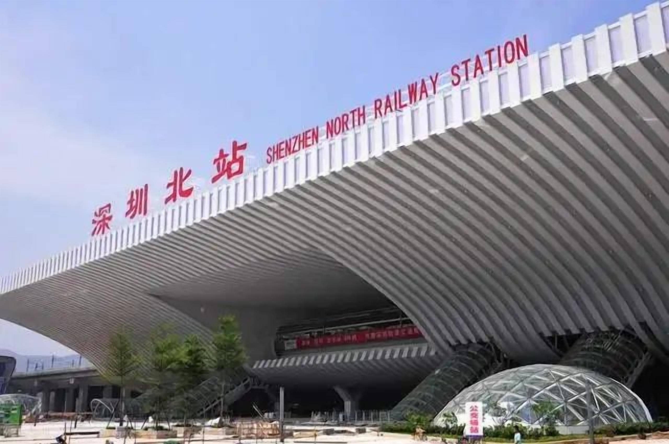 A modern architectural structure with signage indicating it is the Shenzhen North Railway Station.