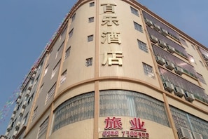 A multi-story hotel with a curved facade, large windows, and balconies.