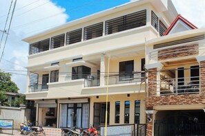 A two-story building with balconies, large windows, and a garage. - RedDoorz @ LS Suites Poblacion Culasi Antique (Culasi)