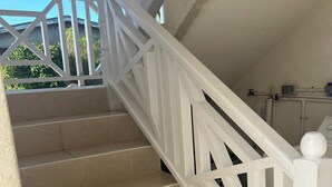 Een witte trap met beige treden en een witte balustrade.