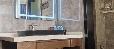 Un baño moderno con un espejo grande, un lavamanos y un inodoro.