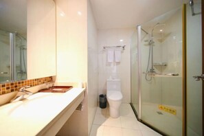 Bathroom features a glass-enclosed shower, white sink, and toilet.