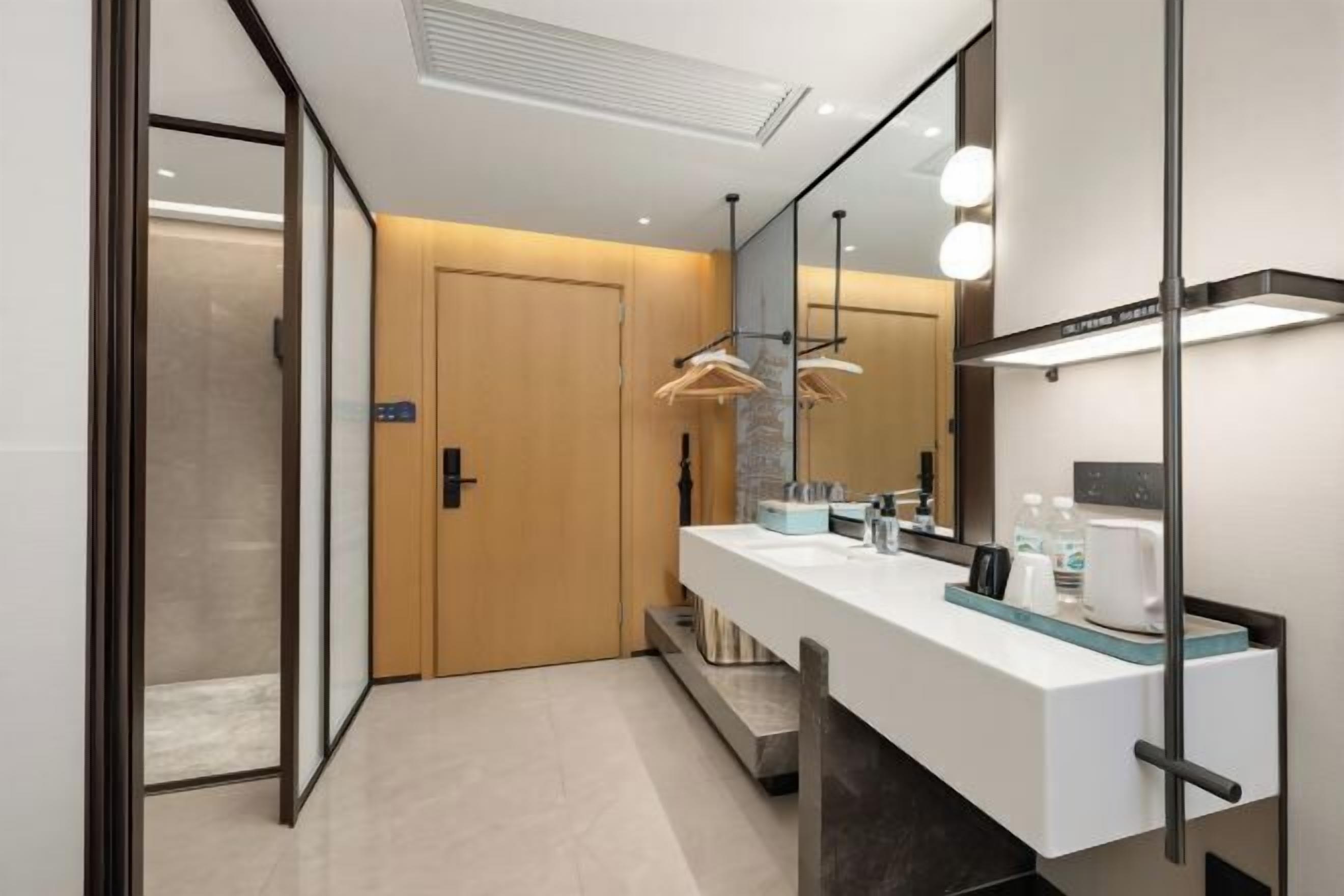 A modern bathroom with a double sink, a mirror, and a towel rack.