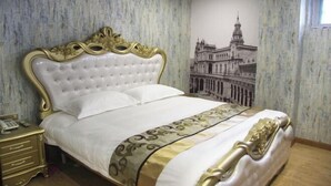 Een slaapkamer met een groot bed, een nachtkastje en een muurschildering.