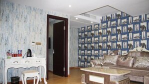 Een woonkamer met een wit bureau, een klein krukje, een bruine bank en een bijzettafeltje.