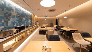 A modern restaurant with a long counter, multiple tables, and chairs. - Homeinn Hotel · neo (Suzhou University Pingjiang Street) (Suzhou)