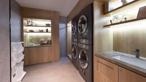 A laundry room with two front-loading washing machines, a sink, and a shelf with toiletries. - Homeinn Hotel · neo (Suzhou University Pingjiang Street) (Suzhou)