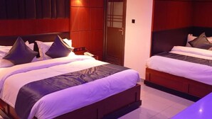 Ein Hotelzimmer mit zwei Betten, Holz-Kopfteilen und einem großen Kleiderschrank.