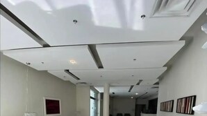 A spacious, modern waiting area with white chairs and tables, a reception desk, and a clean, tiled floor. - Condado Beach Condo - Fast Wi-Fi, AC, Pool & Security 24/7 (San Juan)