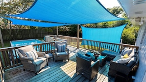 A wooden deck with wicker furniture, a pool, and a blue shade sail. - Luxurious & Comfy Haven: Prime Location ~ Pool ~ Hot Tub ~ Fire Pit ~ Gym ~ Pkg! (Wilmington)