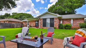 A patio area with a table set for dining, outdoor chairs, and a house in the background. - Maxine's Place- A Wonderful Family Legacy (Abilene)