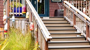 Un escalier en bois mène à une maison sur la porte de laquelle on peut lire l’inscription « Bienvenue ».