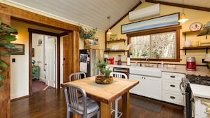 Une cuisine avec des meubles en bois, une table à manger et une fenêtre donnant sur un beau paysage.