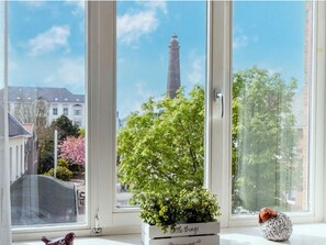 A window with a view of a building and a tree.