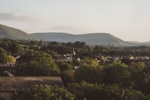A rural village with houses, a church, and rolling hills in the background. - Hot Tub Cabin With Views Over The Brecon Beacons (Brecon)