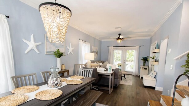 A dining area with a wooden table, woven placemats, and a chandelier. - 3-bedroom townhome in Key West with fitness room, WiFi (Key West)