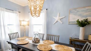 A dining area with a dark wooden table, woven placemats, and a starfish decoration on the wall. - 3-bedroom townhome in Key West with fitness room, WiFi (Key West)
