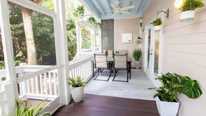 A covered porch with a ceiling fan, white railing, and potted plants. - 3-bedroom townhome in Key West with fitness room, WiFi (Key West)