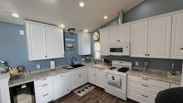 A kitchen with white cabinets, a microwave, a stove, and a dishwasher.