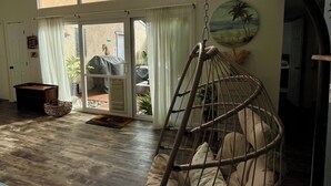 Un espacio amplio con un gran ventanal, un sillón colgante y vistas al exterior.