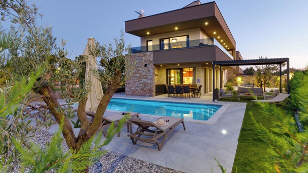 A modern house with a swimming pool, outdoor seating, and a stone wall. - Villa BAVIGO (Istria - Marcana) (Marcana)