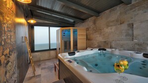 A spa room with a hot tub, wooden beams, stone walls, and a view through large windows. - Villa BAVIGO (Istria - Marcana) (Marcana)