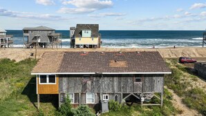 A coastal building with a flat roof, wooden siding, and a small attached structure. - 7038- Hunky Dory - Rodanthe Beach Cottage | 58 Yards to Beach (Rodanthe)