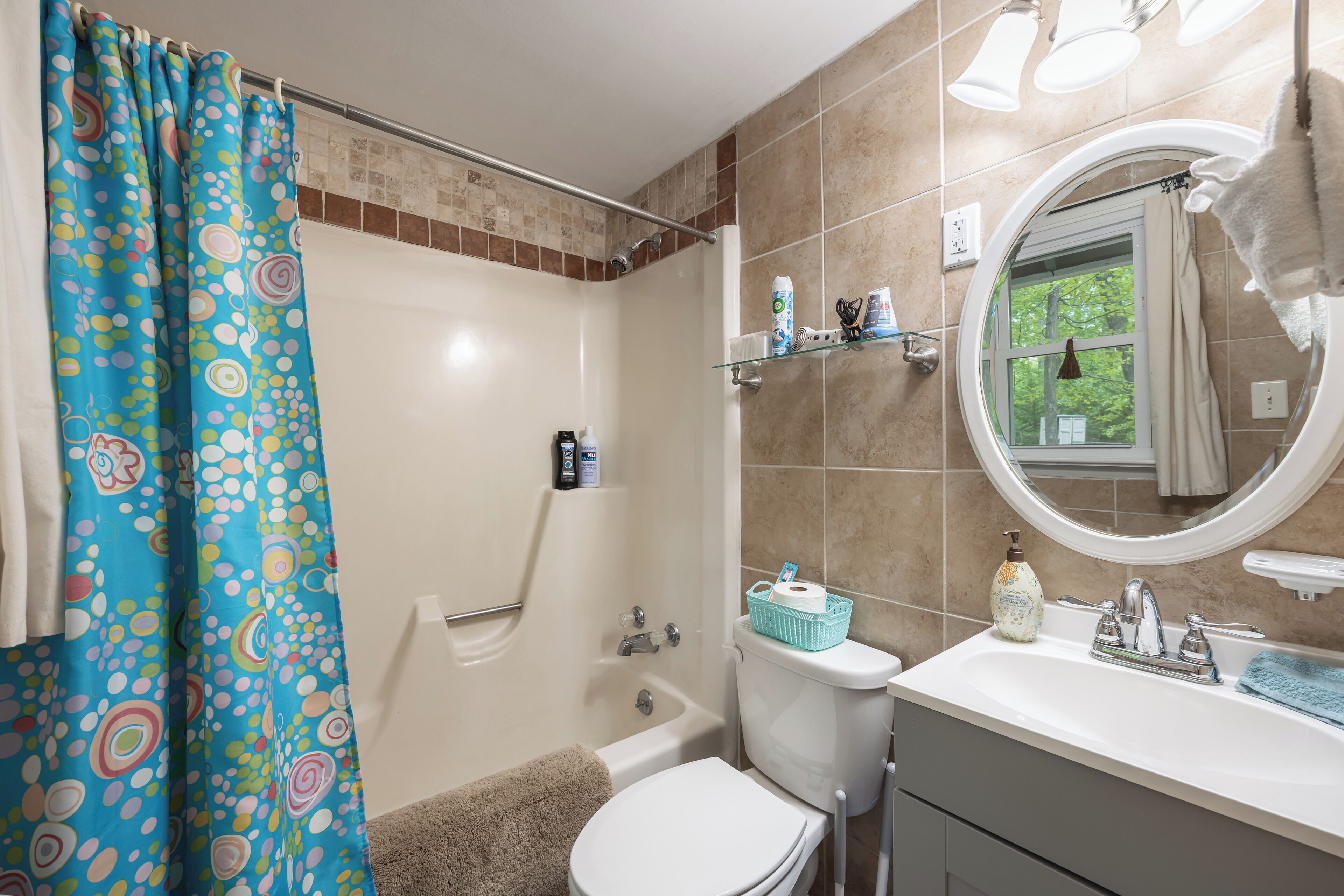 A bathroom with a shower, toilet, and sink.