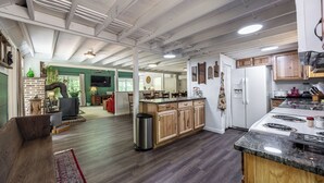 Een ruime keuken met houten kastjes, een groot eiland en een ingebouwde kookplaat.