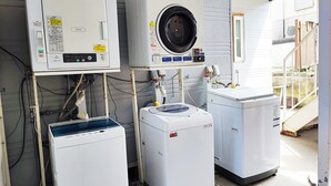 A laundry facility with three washing machines and an air dryer. - Hotel Frontier (Isinomaki)