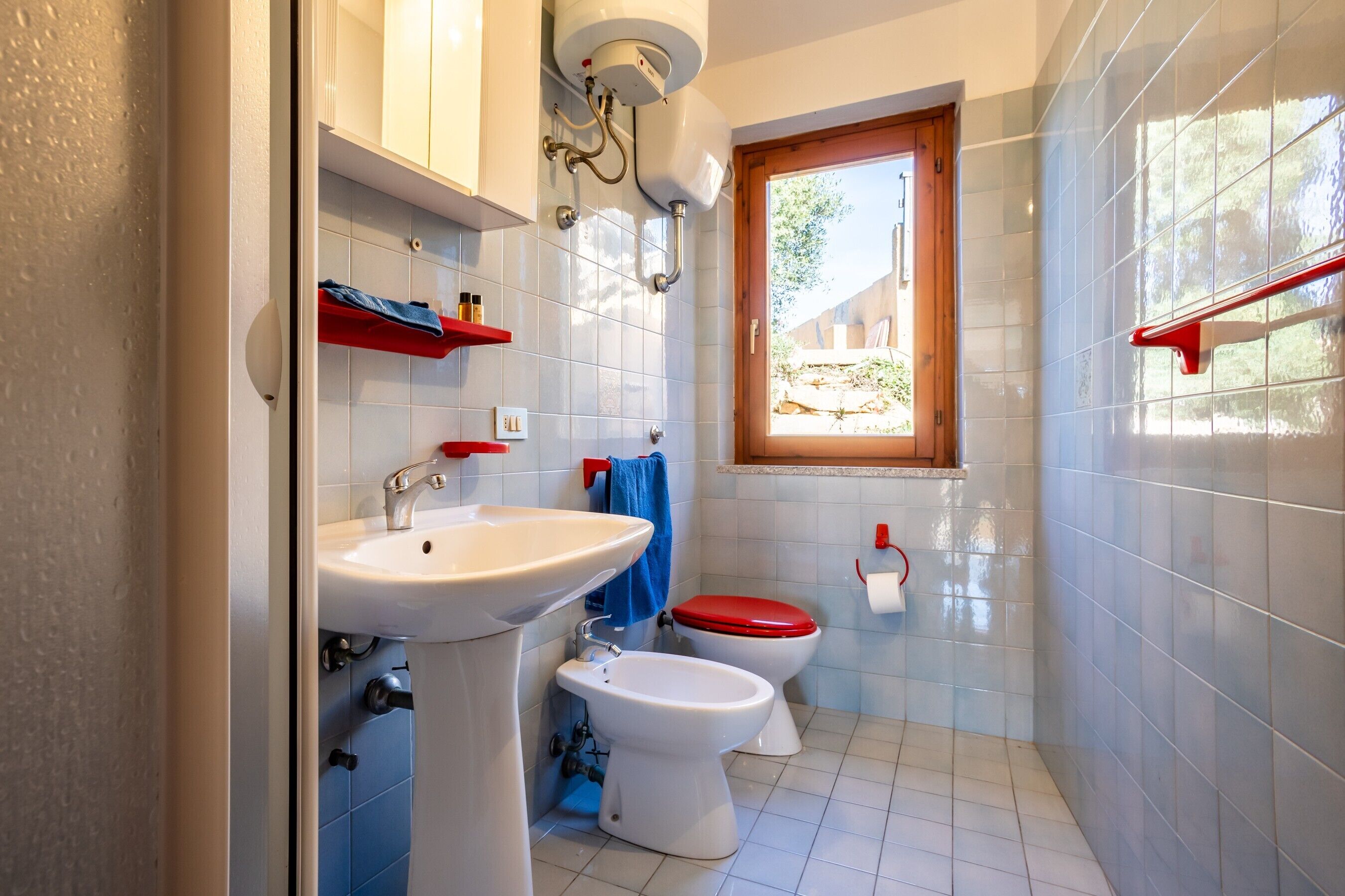 Un baño con lavamanos, inodoro y ducha.