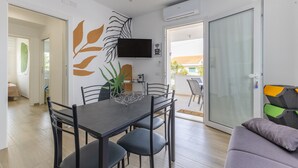 A modern dining area with a dark table, chairs, and a decorative wall piece.