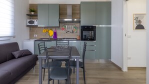 A modern kitchen with a dining area, a built-in oven, and a microwave.