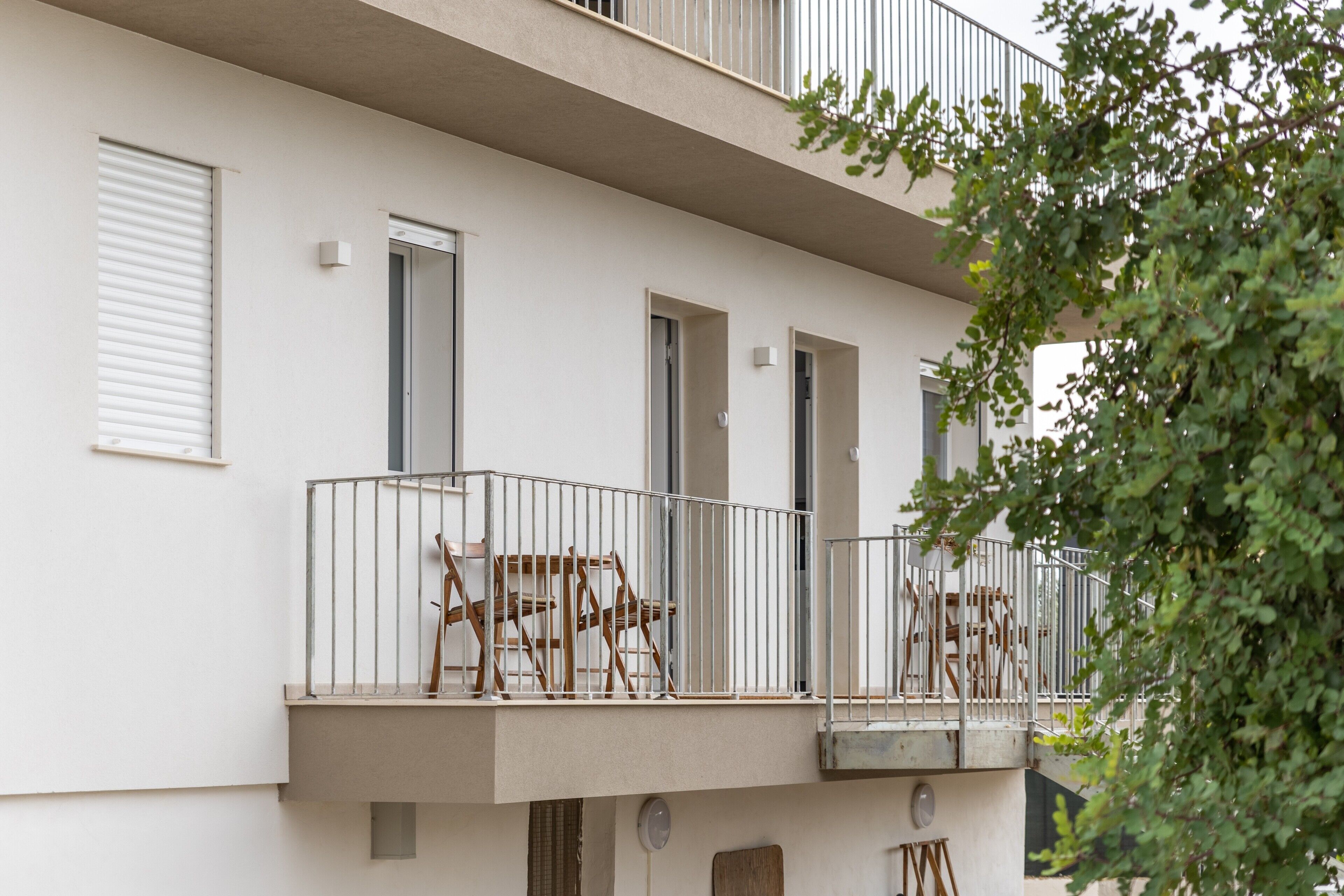 Un immeuble à plusieurs étages doté de balcons, d’une porte et d’une fenêtre.