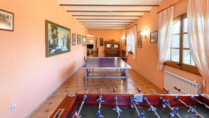 Una habitación con mesa de fútbol, mesa de ping pong y chimenea.
