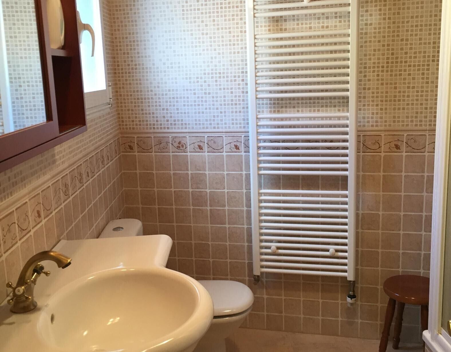 A bathroom with a sink, toilet, and a towel rack.