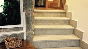 Una escalera con paredes de piedra y barandilla de madera.