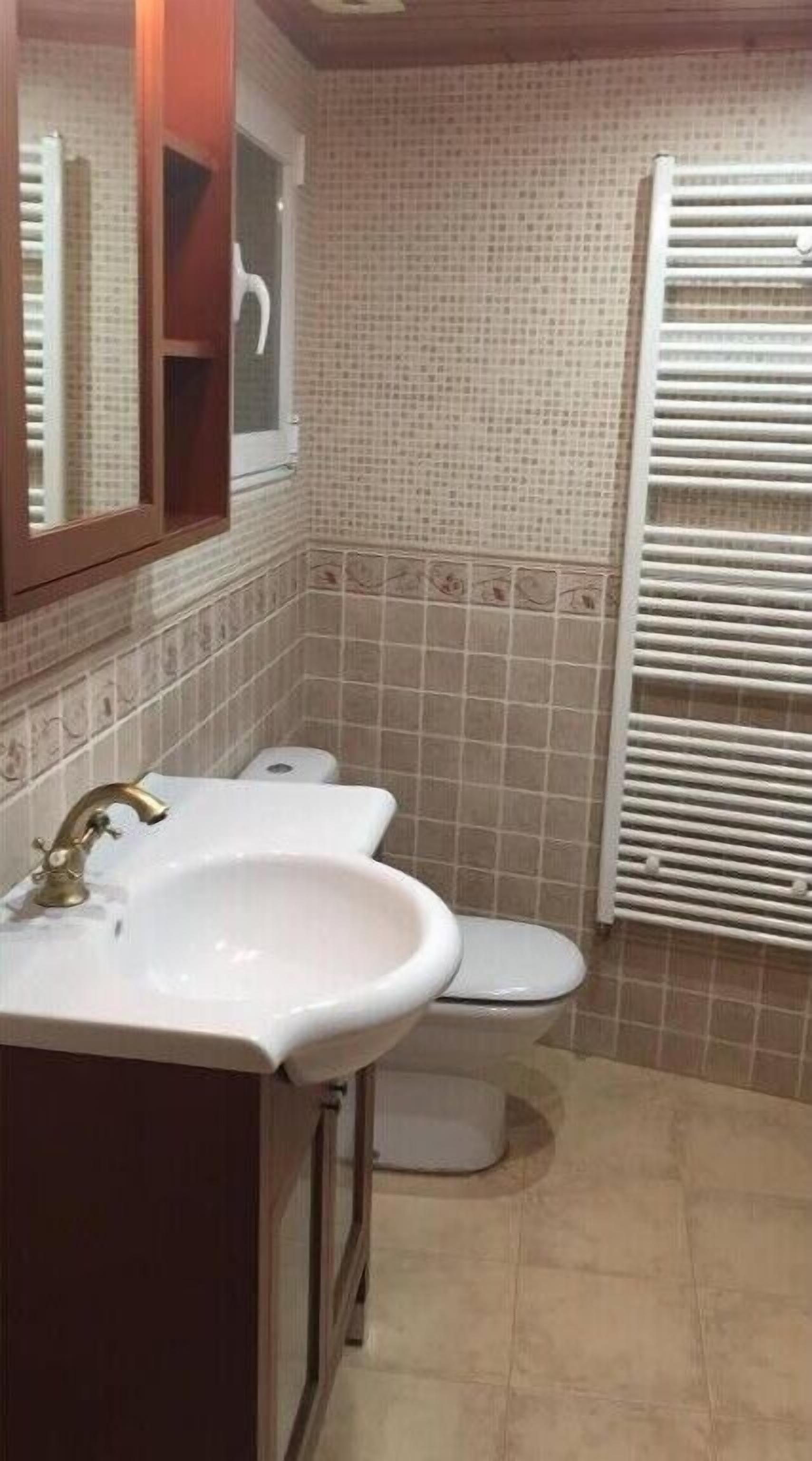 Une salle de bain avec un lavabo, des toilettes et un miroir.