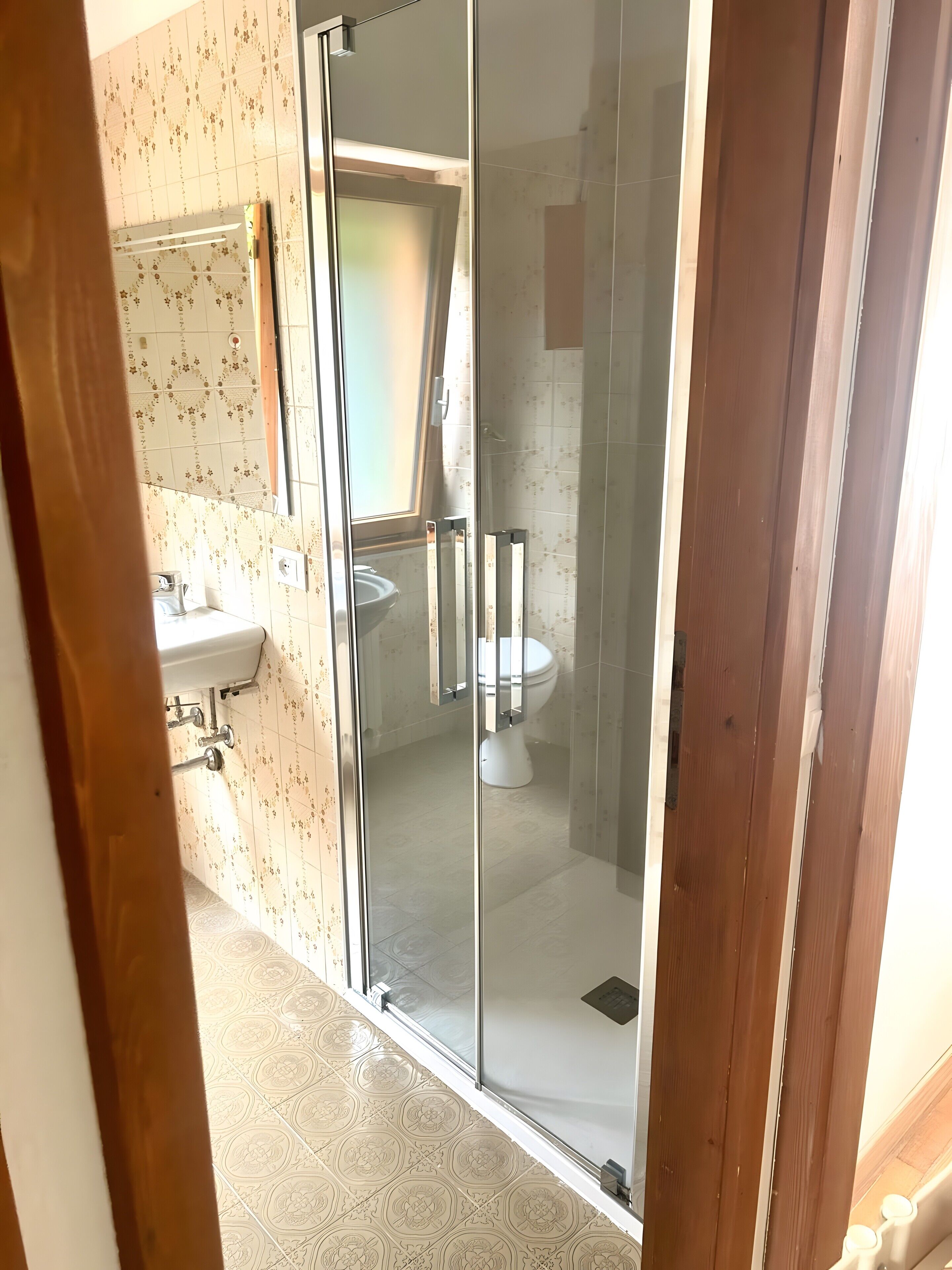 Een badkamer met toilet, douche en wastafel.