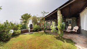 Un espace extérieur aménagé avec un sol en pierre, des sièges et un barbecue.
