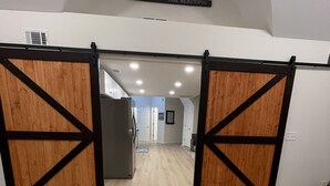 Un intérieur spacieux avec une grande porte en bois donnant sur un couloir.