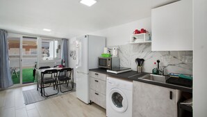 A compact kitchen with a washing machine, microwave, and a small sink.