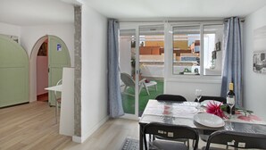 A dining area with a table set for two, a bottle of wine, and a chair.