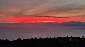 A coastal sunset with a silhouette of a town below. - Holiday Home 'La Cabaña Del Atardecer' with Sea View, Wi-Fi and Air Conditioning (Los Llanos de Aridane)