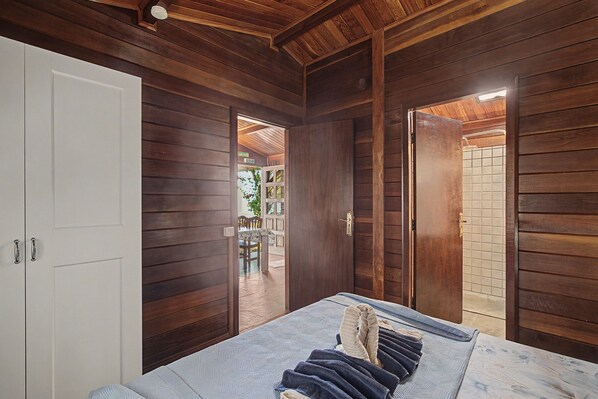 A room with wooden walls and a bed with a blue and white patterned bedspread.