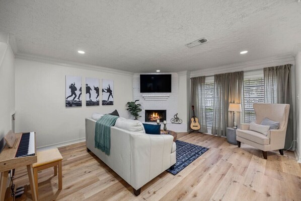 Relax in this stylish living room with a sofa, armchair, and flat-screen TV.