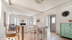 Un vaste espace de vie comprenant une table à manger, des chaises, un canapé et un escalier.