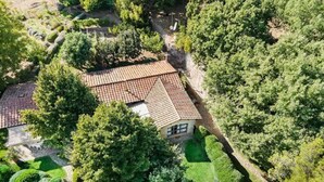 An aerial view of a house with a tiled roof, surrounded by lush greenery and a well-maintained garden. - Villa 'Sunflower' with Private Garden and Wi-Fi (Capalbio)
